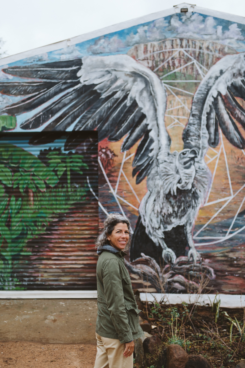 Une femme devant une grande fresque animalière à l'entrée du Kruger