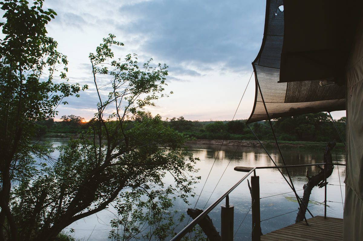 Lumière du crépuscule sur la rivière vue depuis la terrasse d'une tente dans le Grand Kruger