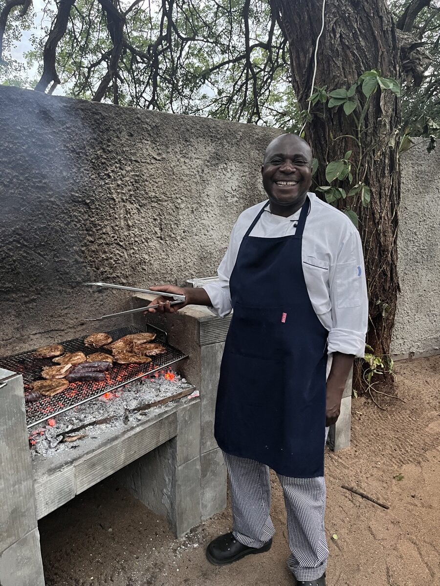 Un chef local souriant devant un braai à bois dans un lodge du KwaZulu-Natal